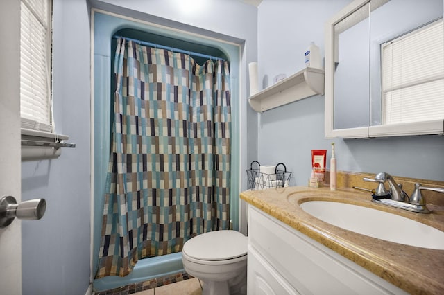 bathroom featuring curtained shower, tile patterned flooring, vanity, and toilet