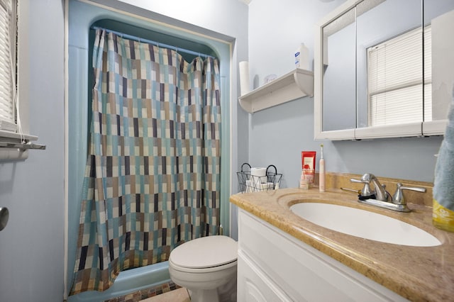 bathroom featuring a shower with shower curtain, vanity, and toilet