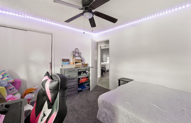 bedroom featuring dark colored carpet, ceiling fan, and a closet