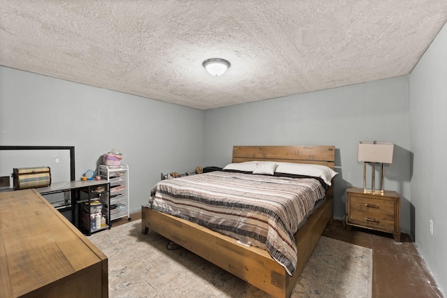 bedroom with a textured ceiling and concrete floors