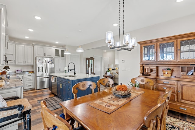 dining room featuring sink, light hardwood / wood-style floors, and a notable chandelier