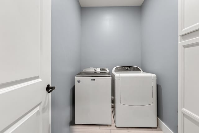 washroom with washer and clothes dryer and light hardwood / wood-style floors