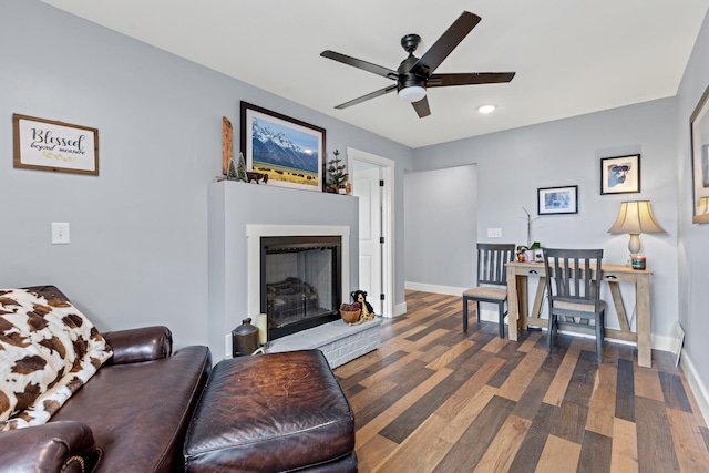 living room featuring a fireplace, dark hardwood / wood-style flooring, and ceiling fan