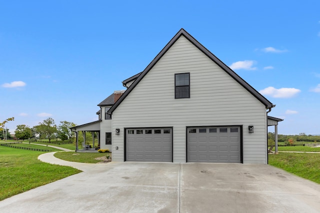 view of side of property featuring a garage and a yard