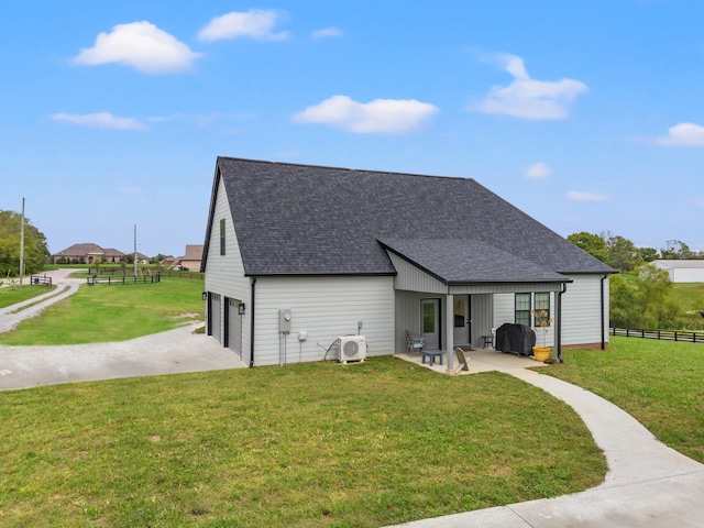 rear view of house with a lawn, a patio, and a garage