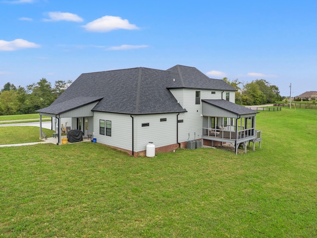 back of property with a lawn and central air condition unit