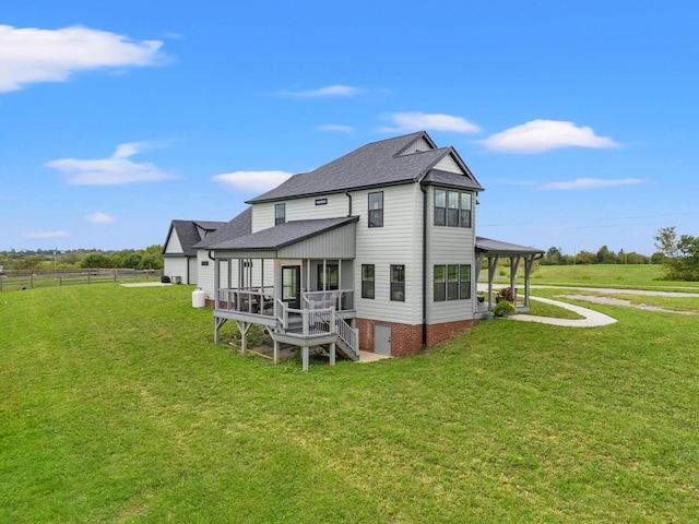 back of house featuring a lawn, a rural view, and a deck