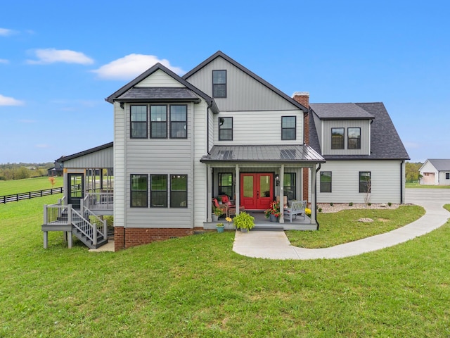 rear view of property featuring a yard, french doors, and covered porch