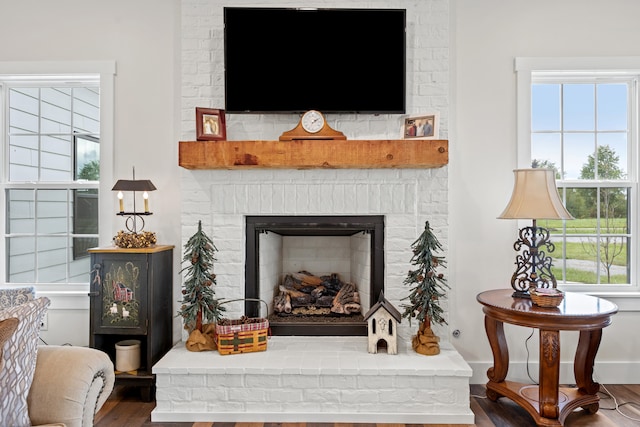 interior space with hardwood / wood-style floors and a brick fireplace