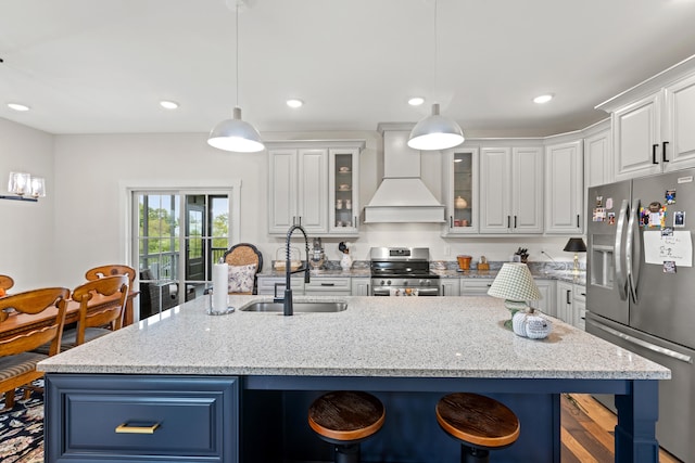 kitchen with light stone counters, custom exhaust hood, stainless steel appliances, pendant lighting, and white cabinetry