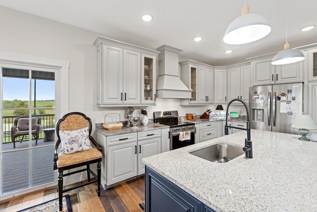 kitchen with custom exhaust hood, sink, dark hardwood / wood-style floors, decorative light fixtures, and stainless steel appliances