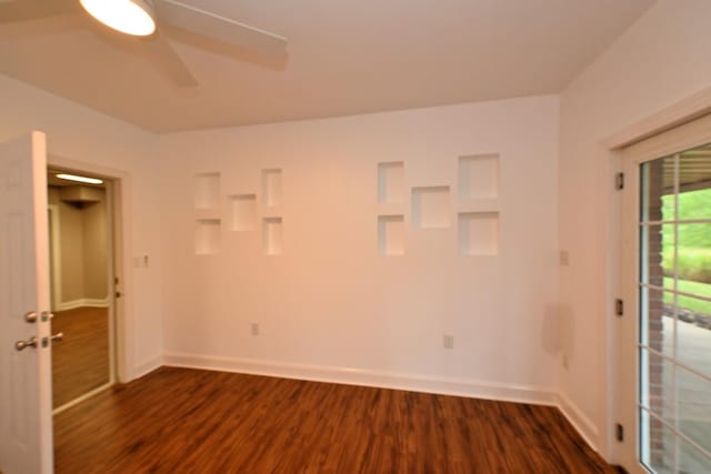 spare room featuring lofted ceiling and dark hardwood / wood-style floors