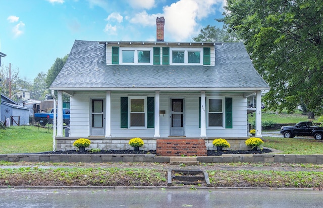 bungalow featuring a front yard and a porch