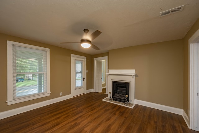 unfurnished living room with ceiling fan, dark wood-type flooring, and a textured ceiling