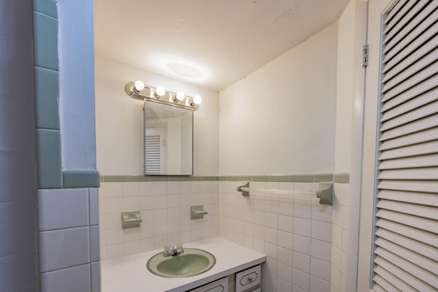 bathroom featuring vanity and tile walls