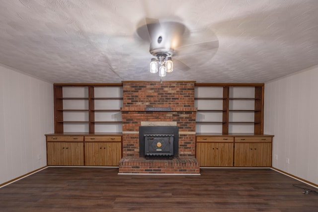 unfurnished living room featuring dark hardwood / wood-style floors, ceiling fan, and a wood stove