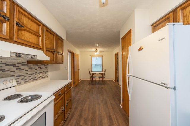 kitchen with white appliances, dark hardwood / wood-style floors, and tasteful backsplash