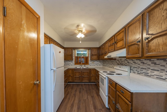 kitchen featuring ceiling fan, sink, dark wood-type flooring, tasteful backsplash, and white appliances