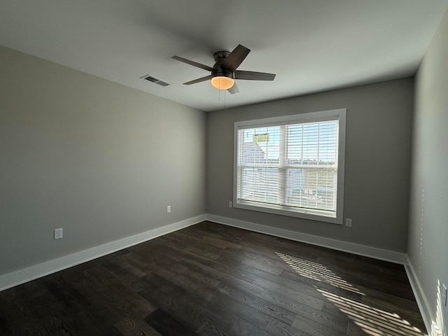 spare room featuring dark wood-type flooring and ceiling fan