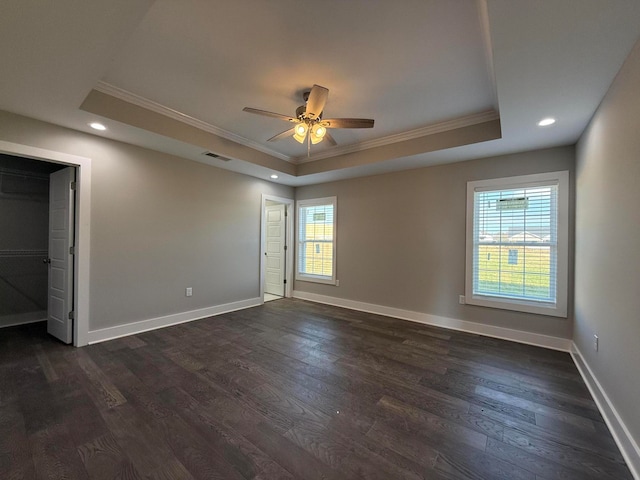 spare room with dark hardwood / wood-style floors, ceiling fan, and a tray ceiling