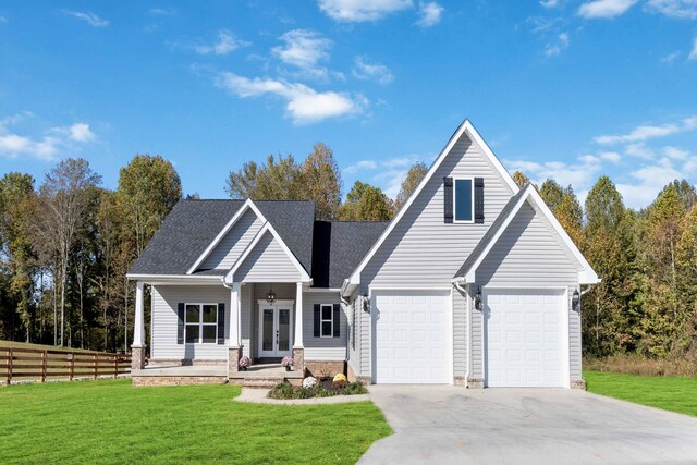 view of front of home with french doors, a garage, and a front lawn