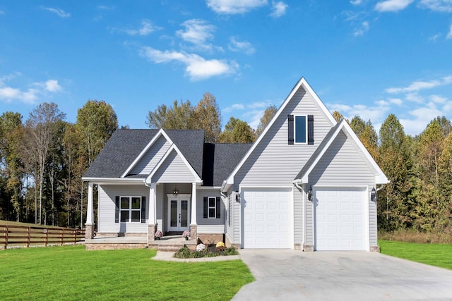 view of front of property with driveway, a front yard, fence, and french doors