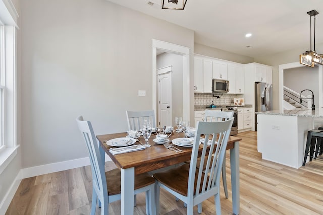 dining area featuring stairs, light wood finished floors, recessed lighting, and baseboards