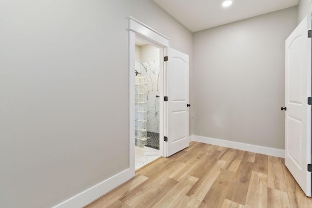 corridor featuring light wood-style floors, baseboards, and recessed lighting