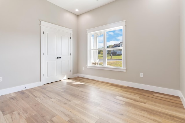 unfurnished bedroom with light wood-style flooring, baseboards, a closet, and recessed lighting