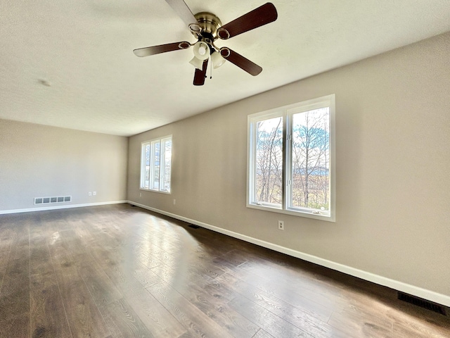 empty room featuring ceiling fan and dark hardwood / wood-style flooring