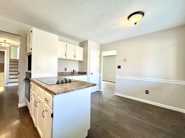 kitchen featuring sink, a textured ceiling, white cabinetry, black appliances, and dark wood-type flooring