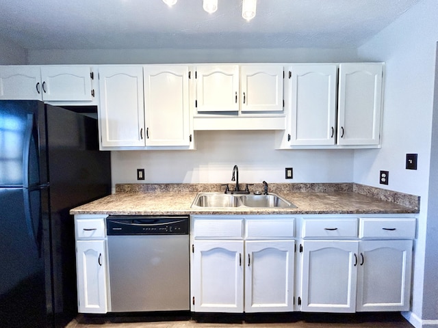 kitchen featuring sink, stainless steel dishwasher, black refrigerator, and white cabinetry