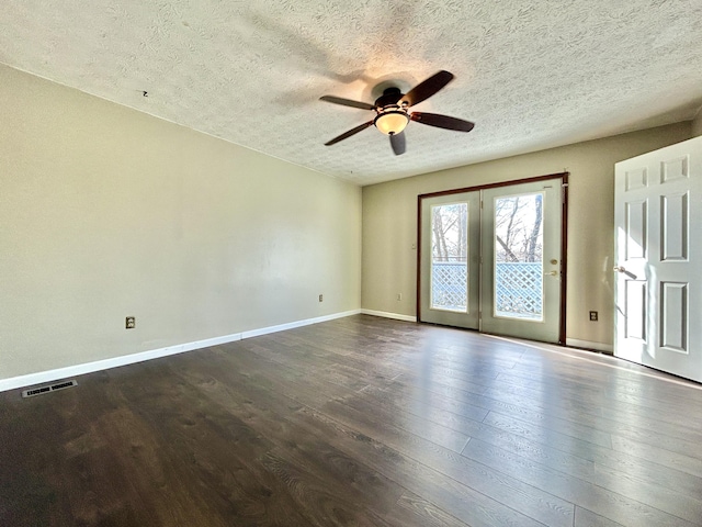 empty room featuring ceiling fan, dark wood-type flooring, and a textured ceiling