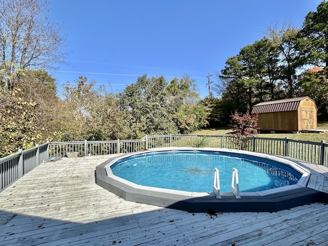 view of pool with a deck and a storage unit