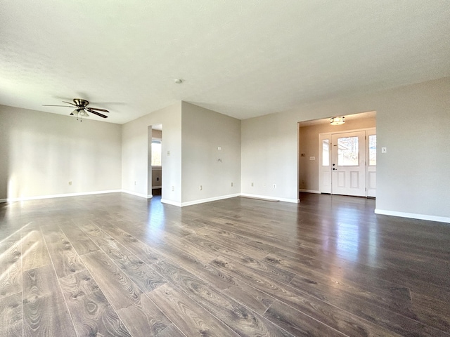 unfurnished room featuring a textured ceiling, ceiling fan, and dark wood-type flooring