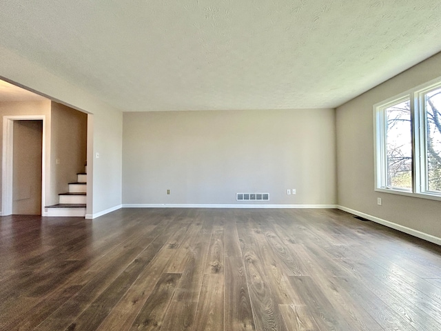 unfurnished room featuring a textured ceiling and dark wood-type flooring