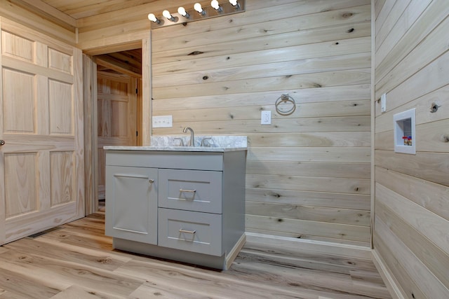 bathroom with vanity, wood-type flooring, and wooden walls