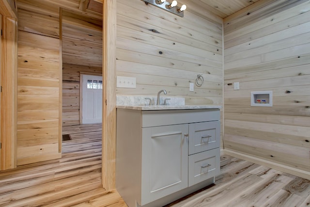 bathroom featuring wood ceiling, wood finished floors, wooden walls, and vanity