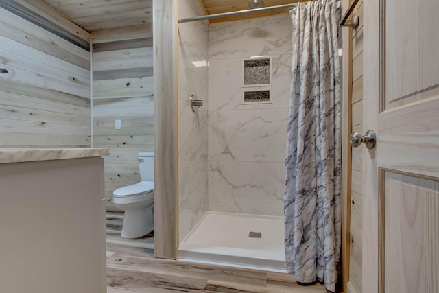 bathroom featuring toilet, wood walls, wood-type flooring, and curtained shower