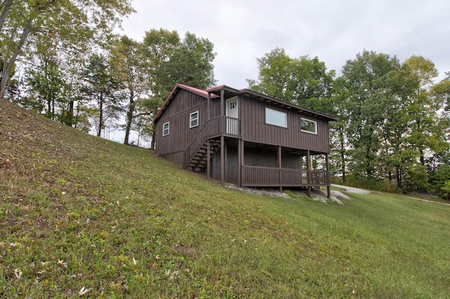 back of property featuring a lawn and stairs