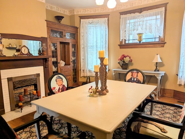 dining area with light wood-type flooring and a fireplace