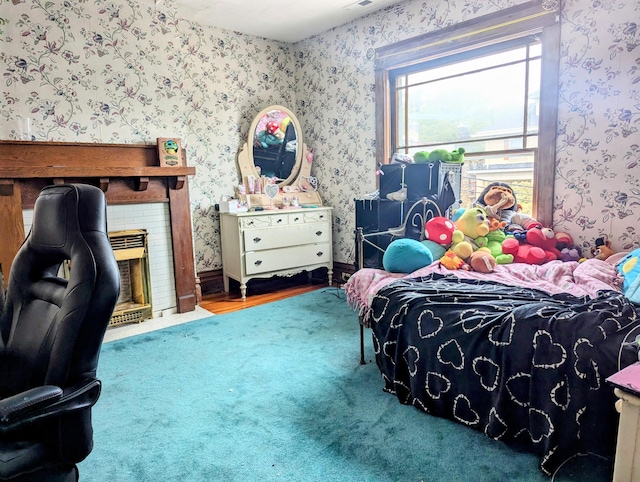 bedroom with a brick fireplace and carpet flooring