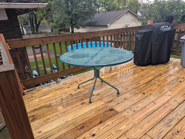 wooden deck featuring a lawn and grilling area