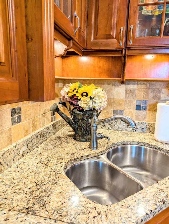 details featuring light stone countertops and sink