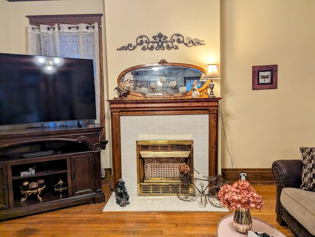 living room featuring a brick fireplace and hardwood / wood-style floors