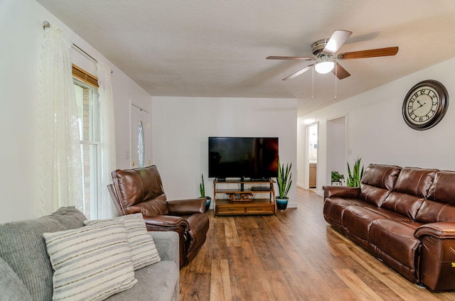 living room with ceiling fan, hardwood / wood-style floors, and a textured ceiling