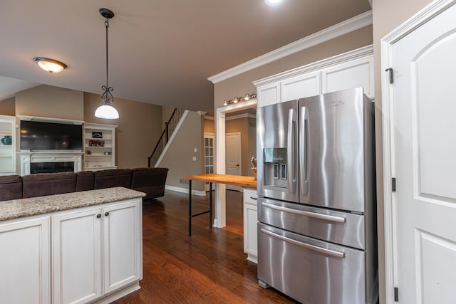 kitchen featuring light stone counters, dark hardwood / wood-style floors, white cabinetry, ornamental molding, and stainless steel fridge