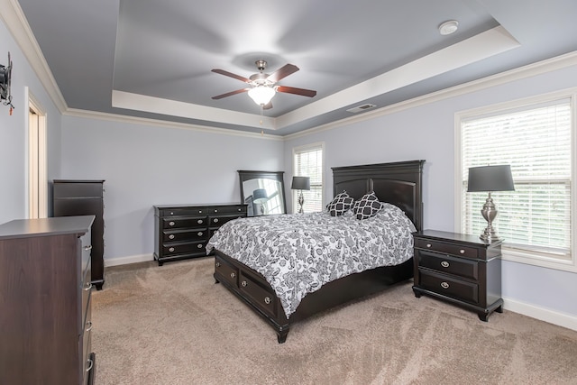 bedroom featuring ceiling fan, a tray ceiling, and light carpet