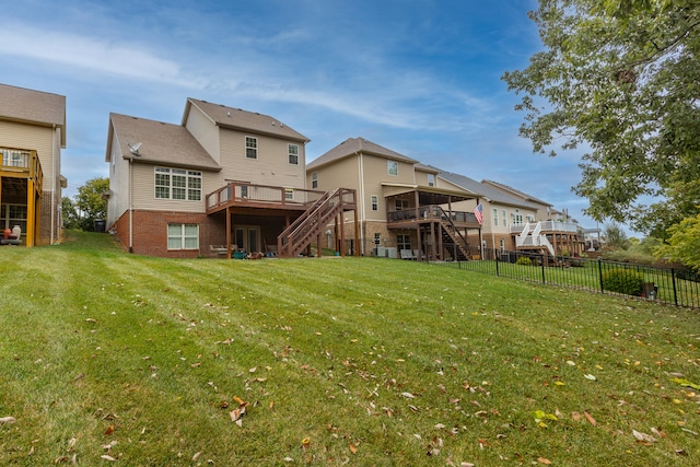 rear view of property featuring a wooden deck and a yard