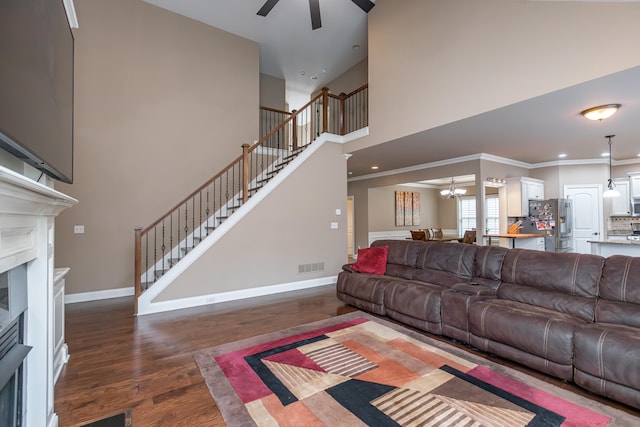 living room featuring ceiling fan, dark hardwood / wood-style floors, and ornamental molding